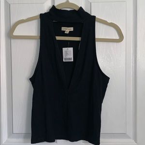High neck tank top with a deep v-neck.